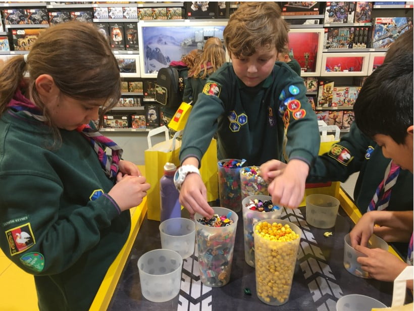 Photo of Coniston Cubs concentrating on building Lego minifigures.